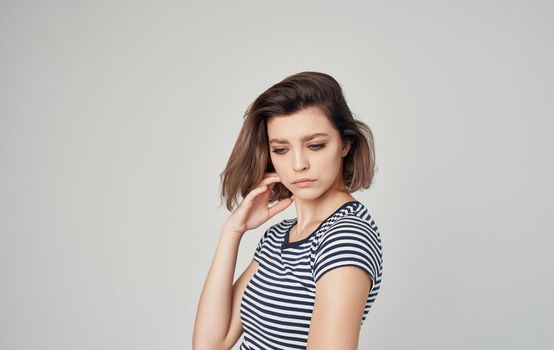 pretty model woman in striped t-shirt gesturing with hands on gray background Copy Space. High quality photo