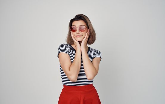 pretty woman in fashion clothes red skirt striped t-shirt sunglasses gesturing with hands. High quality photo