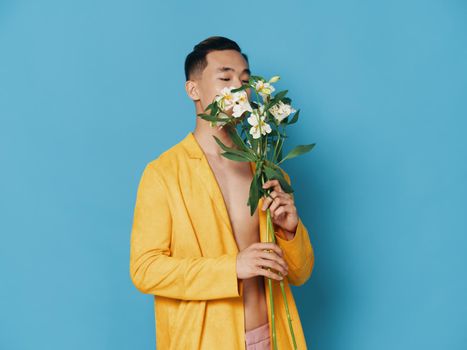 A romantic man in a yellow coat with a bouquet of fragrant flowers. High quality photo
