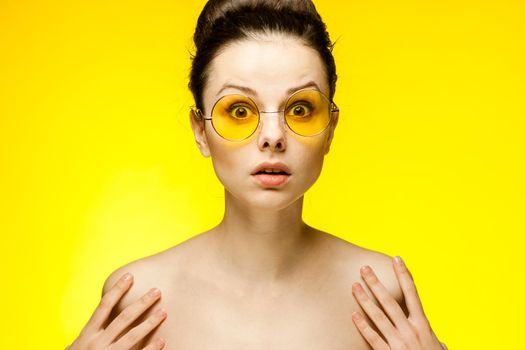 woman with bare shoulders wearing fashion glasses gathered hair. High quality photo
