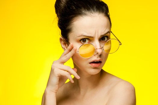 woman with bare shoulders wearing fashion glasses gathered hair. High quality photo
