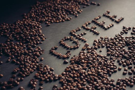 word from coffee beans on gray background close-up drink arabica cappuccino. High quality photo