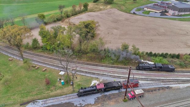 Aerial View of An Antique Restored Steam Locomotive Blowing Smoke and Steam Traveling Thru Farmlands and Countryside on a Sunny Summer Day