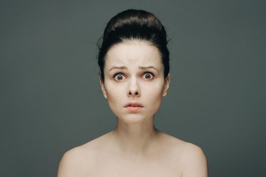 woman with bare shoulders clear skin collected hair emotions. High quality photo
