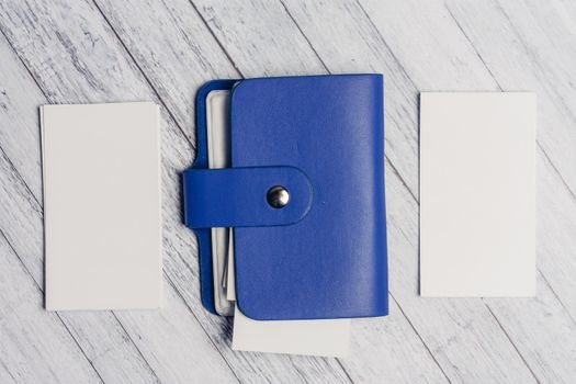 blue business card holder with letterheads on a wooden table top view. High quality photo