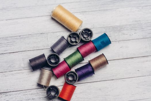 sewing accessories colored threads top view wooden background. High quality photo