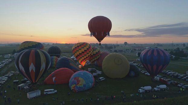 Hot Air Balloons Taking Off at Sunrise at a Hot Air Balloon Festival on a Misty Morning