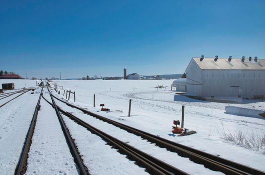 View of Rail Road Tracks Running Thru the Countryside Covered in Snow