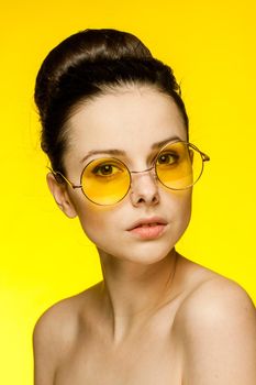 woman with bare shoulders wearing fashion glasses gathered hair. High quality photo