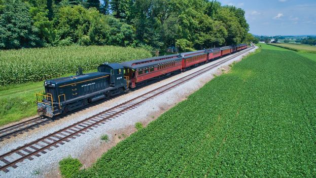 Aerial View of An Antique Restored Diesel Locomotive Traveling Thru Farmlands and Countryside on a Sunny Summer Day