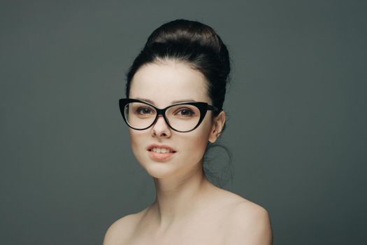 pretty woman naked shoulders gathered hair glasses emotions. High quality photo