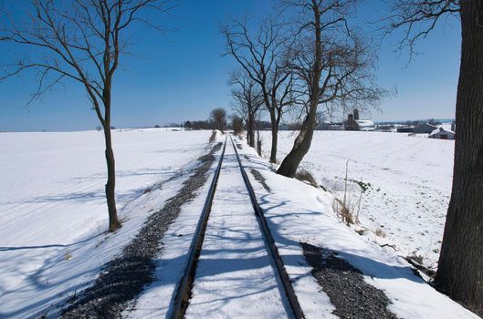 View of Rail Road Tracks Running Thru the Countryside Covered in Snow
