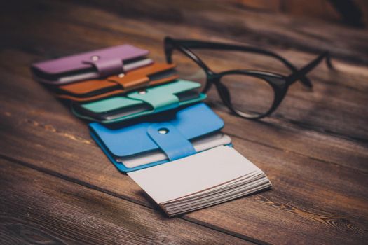 business card holder and glasses with black frames on the table a pack of white paper. High quality photo