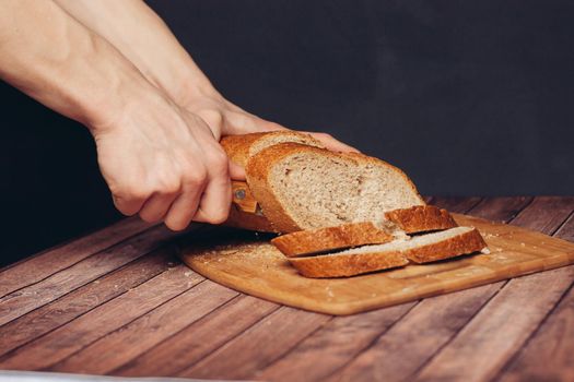 slicing fresh bread on a wooden cutting board breakfast meal. High quality photo