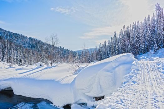 Winter landscape in the highlands and a small bridge over the river