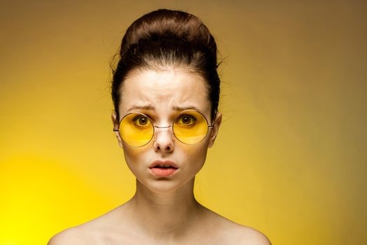 brunette with bare shoulders yellow glasses attractive look. High quality photo