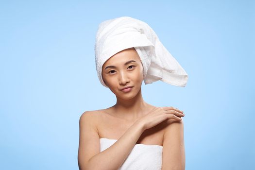 pretty woman naked shoulders towel on head clean skin care blue background. High quality photo