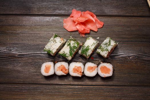 set of sushi and rolls on a wooden table asian food ginger wasabi japanese cuisine. High quality photo