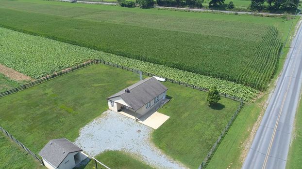 Aerial View of an Amish One Room School House in the Middle Of Amish Farmlands on a Sunny Day