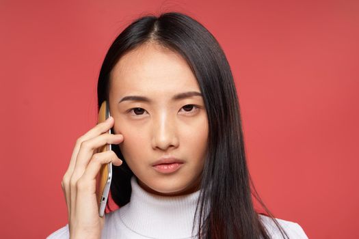 pretty brunette talking on the phone technology close-up red background. High quality photo