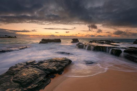 colorful sunrise with dramatic sky from Sandy Beach, Oahu, Hawaii USA