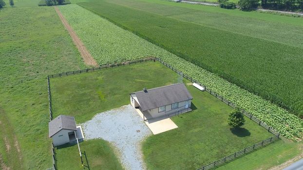 Aerial View of an Amish One Room School House in the Middle Of Amish Farmlands on a Sunny Day