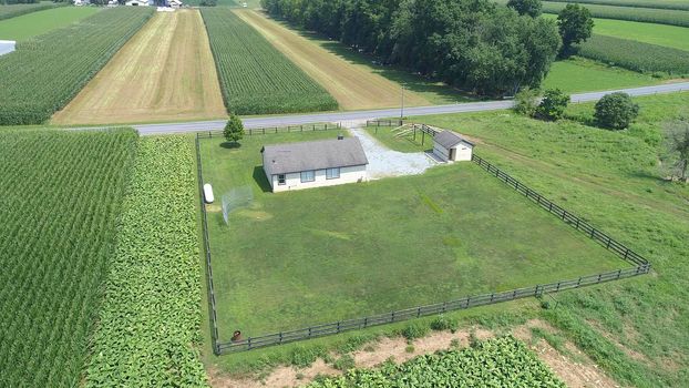 Aerial View of an Amish One Room School House in the Middle Of Amish Farmlands on a Sunny Day