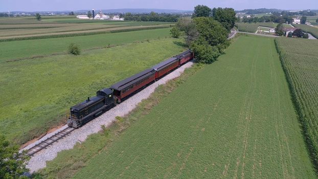 Aerial View of An Antique Restored Diesel Locomotive Traveling Thru Farmlands and Countryside on a Sunny Summer Day