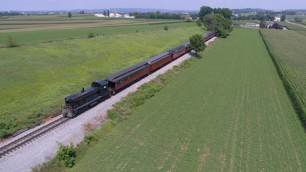 Aerial View of An Antique Restored Diesel Locomotive Traveling Thru Farmlands and Countryside on a Sunny Summer Day