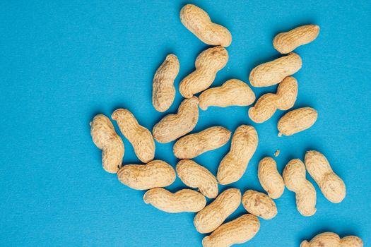 peanuts in shell blue background close-up top view. High quality photo