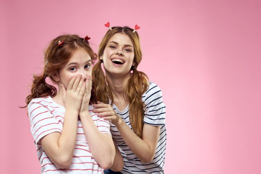 Woman and little girl on a pink background fun sisters friends family. High quality photo