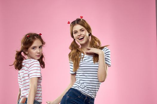 funny girlfriends with clothespins hair on a pink background sisters. High quality photo