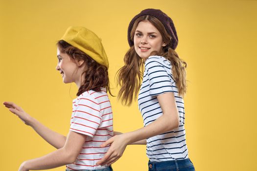 Mom and daughter embrace joy fun childhood lifestyle yellow background. High quality photo
