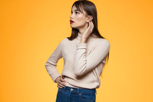 Cute brunette makeup red lips fashionable clothes yellow background. High quality photo