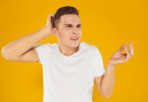A man in a white t-shirt is touching himself with a hand on an isolated background cropped view. High quality photo