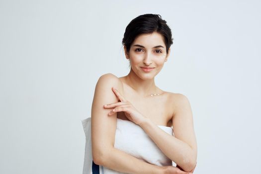 Pretty brunette bare shoulders white towel clean skin shower. High quality photo