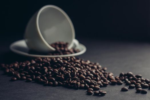 cup and saucer coffee beans morning breakfast close-up dark background. High quality photo