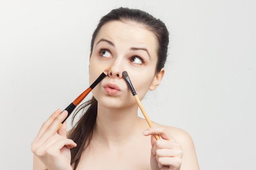 pretty brunette applying makeup skin care cosmetics cropped view. High quality photo