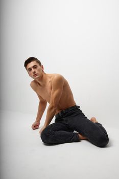 male topless sitting on the floor black pants model. High quality photo