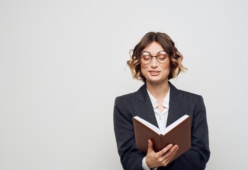 Woman in classic suit with open book glasses on face cropped view. High quality photo