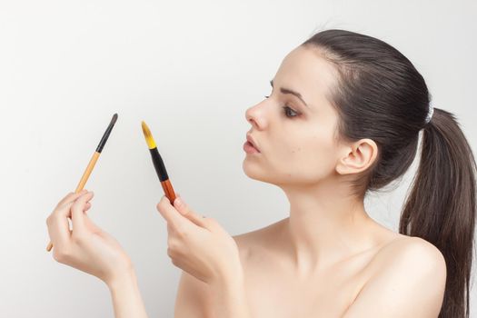 brunette with cream face mask skin care brush applying makeup. High quality photo
