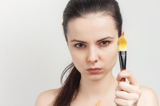 brunette brushing cream on face skin care cropped view. High quality photo