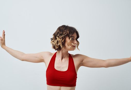 Woman in sportswear on a light background gestures with her hands yoga asana. High quality photo