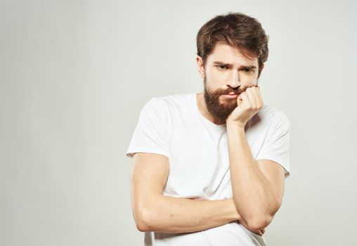 Man touches face with hands emotions model light background. High quality photo