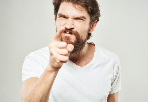 emotional man gesturing with his hands on a light background aggression scream. High quality photo