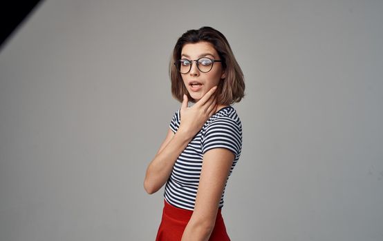 portrait of a happy blonde in a striped t-shirt and his glasses on a gray background. High quality photo