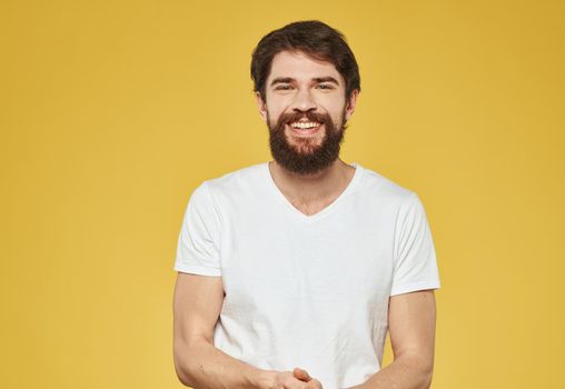Portrait of a man bushy beard mustache white t-shirt yellow background cropped view. High quality photo