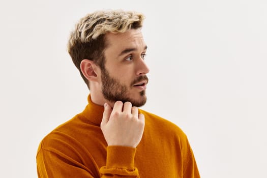 handsome man fashion hairstyle hand near face cropped view light background. High quality photo