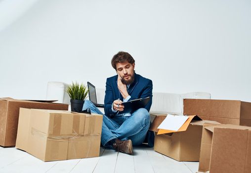 A man in a suit boxes with things communicating on the phone office official unpacking. High quality photo