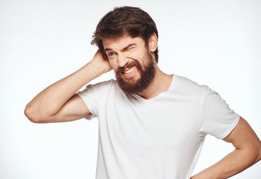 A man in a white T-shirt on a light background beautiful face Happy look. High quality photo